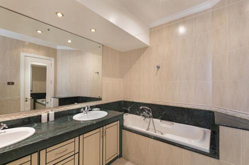 a bathroom with two sinks and a large mirror at Apartment Orchid in Mont Choisy