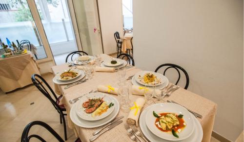 a table with plates of food on it at Hotel Massimo in Riccione