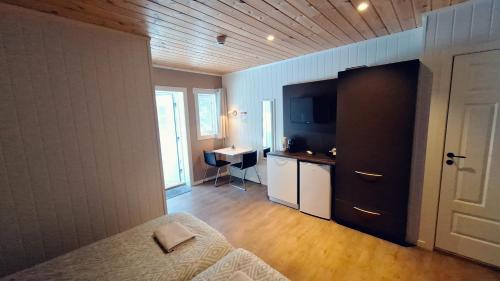 a bedroom with a bed and a desk and a sink at Telemark Motel and Apartment in Hauggrend