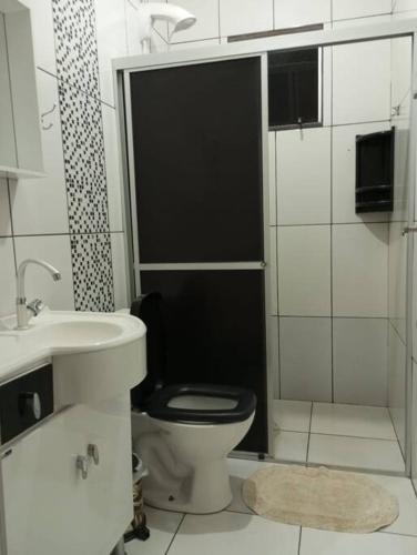a bathroom with a black toilet and a sink at Cabana 2 qts com Ar-condicionado in Machadinho