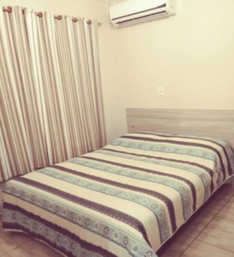 Bett in einem Zimmer mit Heizkörper in der Unterkunft Cabana 2 qts com Ar-condicionado in Machadinho