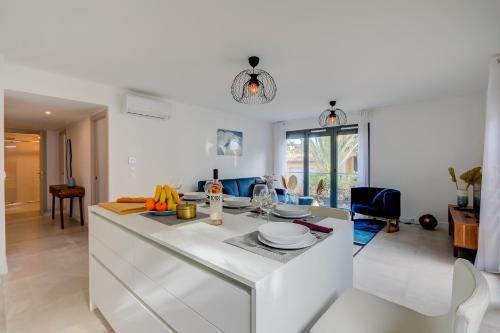 une cuisine et un salon avec un comptoir blanc dans l'établissement L'Ecrin 101 - Golfe de Saint-Tropez - Happy Rentals, à Sainte-Maxime