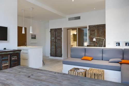 un salon avec un canapé bleu et une cuisine dans l'établissement Les Barques, Vue splendide sur le port de Cassis, à Cassis