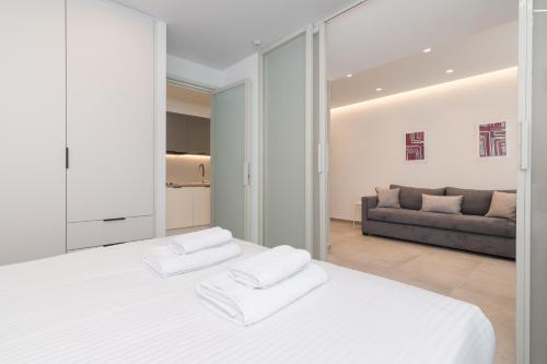 a white bedroom with a large bed and a couch at Athens Theatrou Apartments in Athens