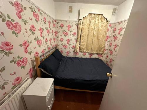 a small bedroom with a bed and floral wallpaper at Sweet dream 3 in London