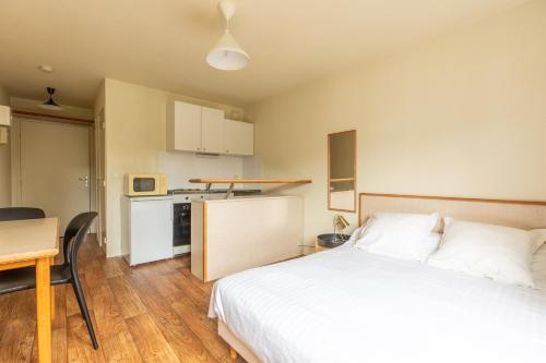 une chambre avec un lit et une table et une cuisine dans l'établissement Résidence Les Dômes, à Royat