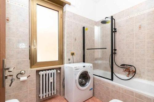 a bathroom with a washing machine next to a bath tub at appartamento a pochi passi dalla stazione comodo a coppie e famiglie, casa Ferrucci in Collegno