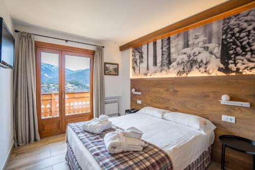 a hotel room with a bed and a large window at Abba Ordino Babot Hotel in Ordino