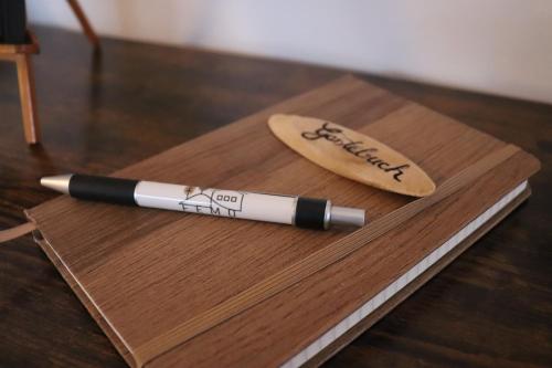 a pen sitting on top of a wooden cutting board at Femo SCHICK-modern, Natur, Rothaarsteig, 2Etg, 2Bäder in Burbach