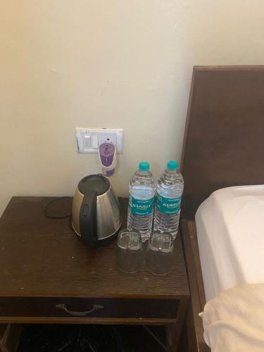 two bottles of water on a table next to a bed at Baga Beach Crystal in Baga