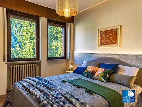a bedroom with a large bed with two windows at [Asiago Centre] New Modern House in Asiago