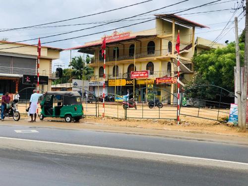 un pequeño vehículo verde estacionado frente a un edificio en Nallur Mylooran Arangam en Jaffna