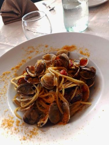 a plate of pasta with mussels on a table at Hotel La Ciaccia in Valledoria
