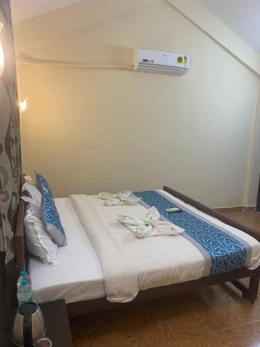 a bed in a room with a heater on the wall at Baga Beach Crystal in Baga