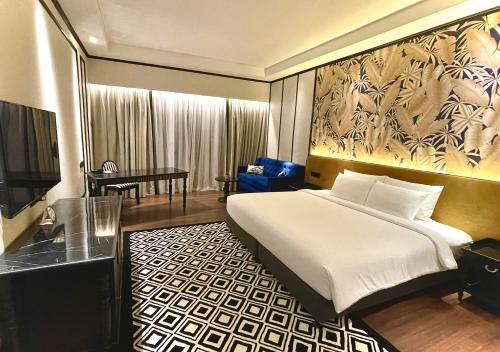Bangi Resort Hotel في بانغي: غرفة نوم بسرير وطاولة وتلفزيون