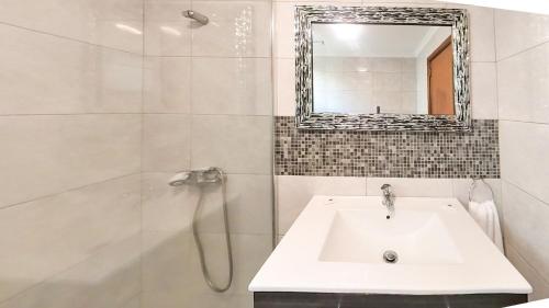 a white bathroom with a sink and a mirror at LIDO CASA BRANCA in Funchal