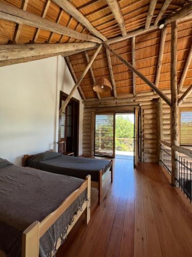 1 dormitorio con 2 camas en una habitación con techos de madera en La Porteña en Gualeguaychú