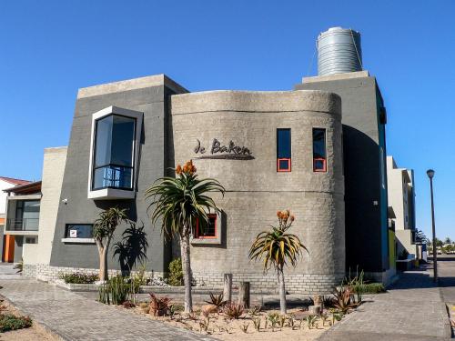 a building with palm trees in front of it at de Baken Self-Catering in Walvis Bay