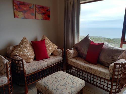 a living room with two chairs and a window at 110 Bay View in Brenton-on-Sea