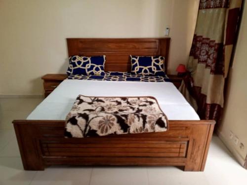 um quarto com uma cama grande e almofadas azuis e brancas em Appartement meublé liberté 6 em Dakar