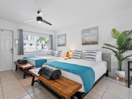 a bedroom with two beds and a potted plant at Siesta By The Beach in Pompano Beach