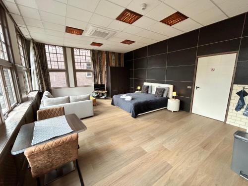 - un salon avec un canapé et un lit dans une chambre dans l'établissement Stylish Studio S1, City Centre Dordrecht, à Dordrecht