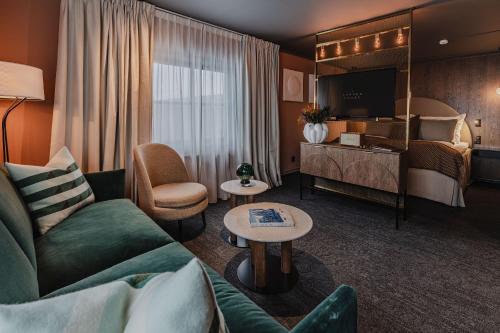 ein Hotelzimmer mit einem Sofa und einem Bett in der Unterkunft Funken Lodge in Longyearbyen