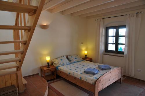 a bedroom with a bed with two lamps and a ladder at Fazendinha - Tavira - Spacious and tranquil in Tavira