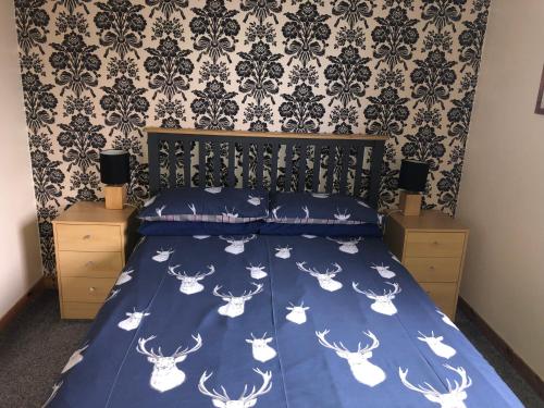 a bedroom with a bed with a blue comforter at Number 12 Self Catering in Portree