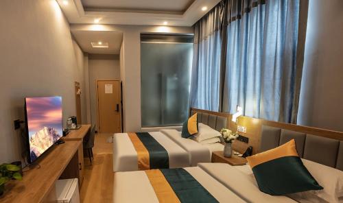 een hotelkamer met 2 bedden en een raam bij Zebulun Hotel in Lijiang