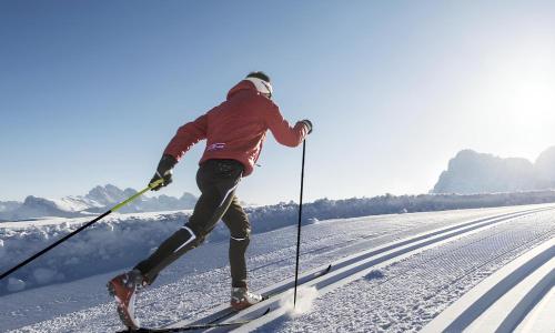 un hombre está esquiando por una pista cubierta de nieve en Le Crode, en Sesto