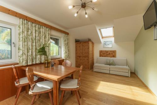 ein Esszimmer mit einem Tisch, Stühlen und einem Sofa in der Unterkunft Stögergut by Schladming-Appartements in Schladming