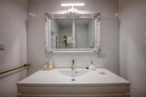 a white bathroom with a sink and a mirror at Lividus339 in Świnoujście