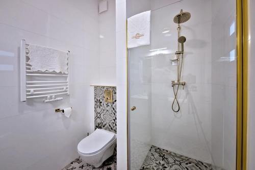 a white bathroom with a toilet and a shower at Lividus339 in Świnoujście