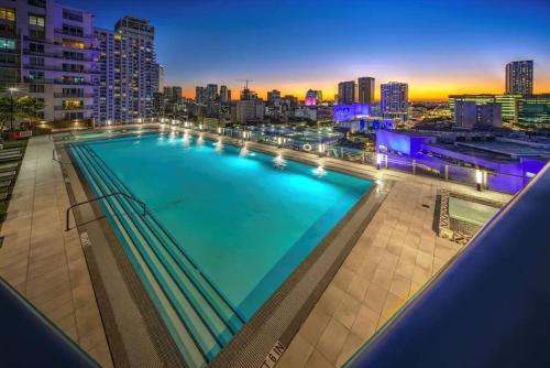 a large swimming pool with a city skyline in the background at Luxury 2BR Corner Apt Downtown MIA in Miami