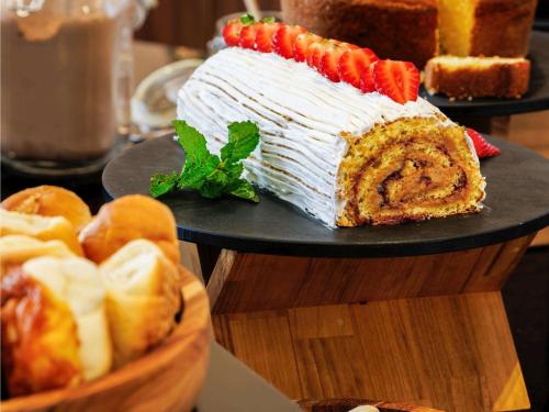 a large cake on a table with a basket of bread at ibis Belo Horizonte Liberdade in Belo Horizonte