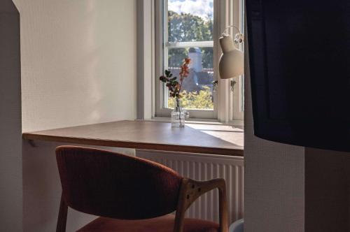 a chair and a vase with flowers in a window at Best Western Solhem Hotel in Visby