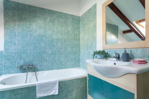 Un baño con lavabo, bañera y espejo. en Heart of NoLo - Meryggiare Apartments, en Milán