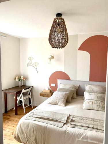 a bedroom with a large bed and a desk at Charmante maison Cabourg in Cabourg