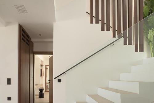 a staircase in a house with white walls at Asea Villa, Spectacular right-on-the-beach Retreat, By ThinkVilla in Skaleta