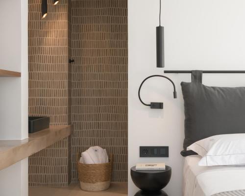 a bedroom with a bed and a clock on the wall at Asea Villa, Spectacular right-on-the-beach Retreat, By ThinkVilla in Skaleta