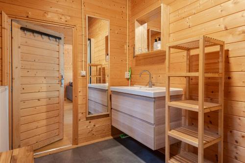 een badkamer met een wastafel en houten wanden bij Chalet Zandvoort in Zandvoort