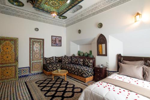 a living room with a bed and a couch at Riad Sayeda Al Hora in Fès