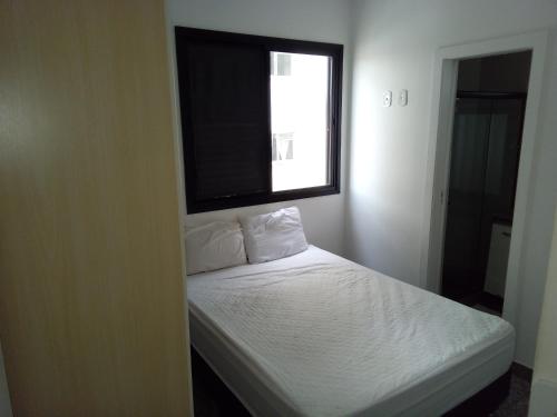 - une petite chambre avec un lit blanc et une fenêtre dans l'établissement Apartamento Solon, à Cabo Frio