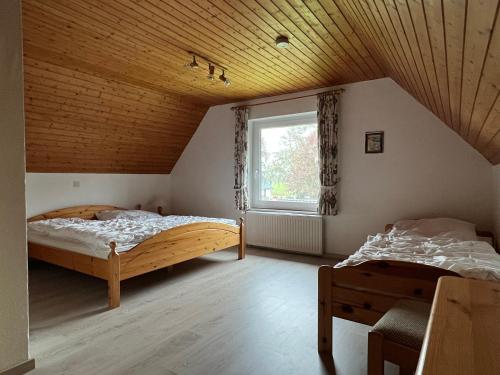 Un dormitorio con dos camas y una ventana. en Ferienhaus Küste, en Otterndorf