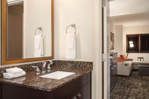 a bathroom with a sink and a mirror at Embassy Suites by Hilton Orlando Lake Buena Vista South in Kissimmee