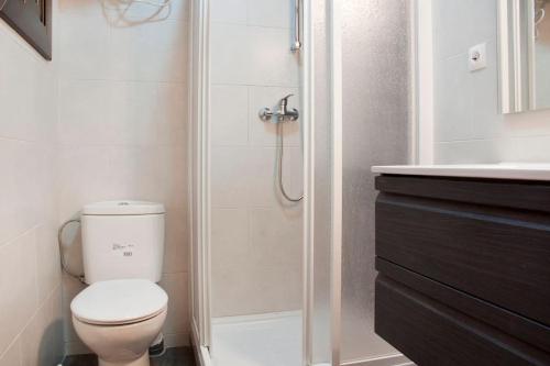 uma casa de banho com um WC, um chuveiro e um lavatório. em Apartamento Cerca del Mar em Badalona