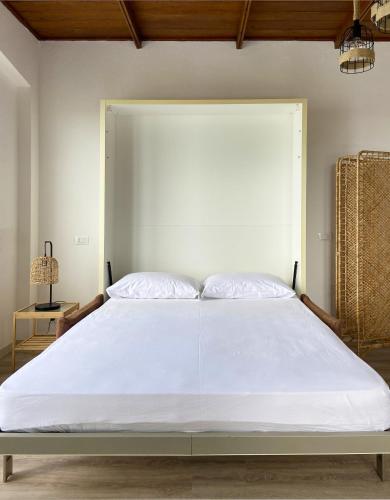 a bedroom with a large white bed with a large headboard at Residence Intur in Marciana Marina