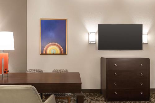 a dining room with a table and a tv at Embassy Suites by Hilton Orlando Lake Buena Vista South in Kissimmee
