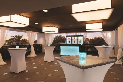 a lobby with a table and some white stools at Embassy Suites by Hilton Orlando Lake Buena Vista South in Kissimmee